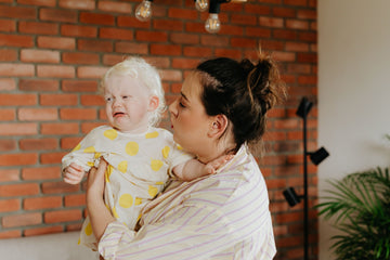 Madre consolando a su bebé, a punto de llorar por la ansiedad de separación