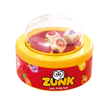 Juego Zunk con base amarilla y roja y una cúpula transparente que contiene dados de frutas y verduras.