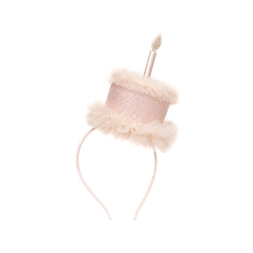 Diadema rosa con adorno de tarta y vela.
