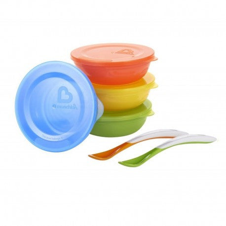 Cuatro cuencos apilados con tapas y dos cucharas al lado
