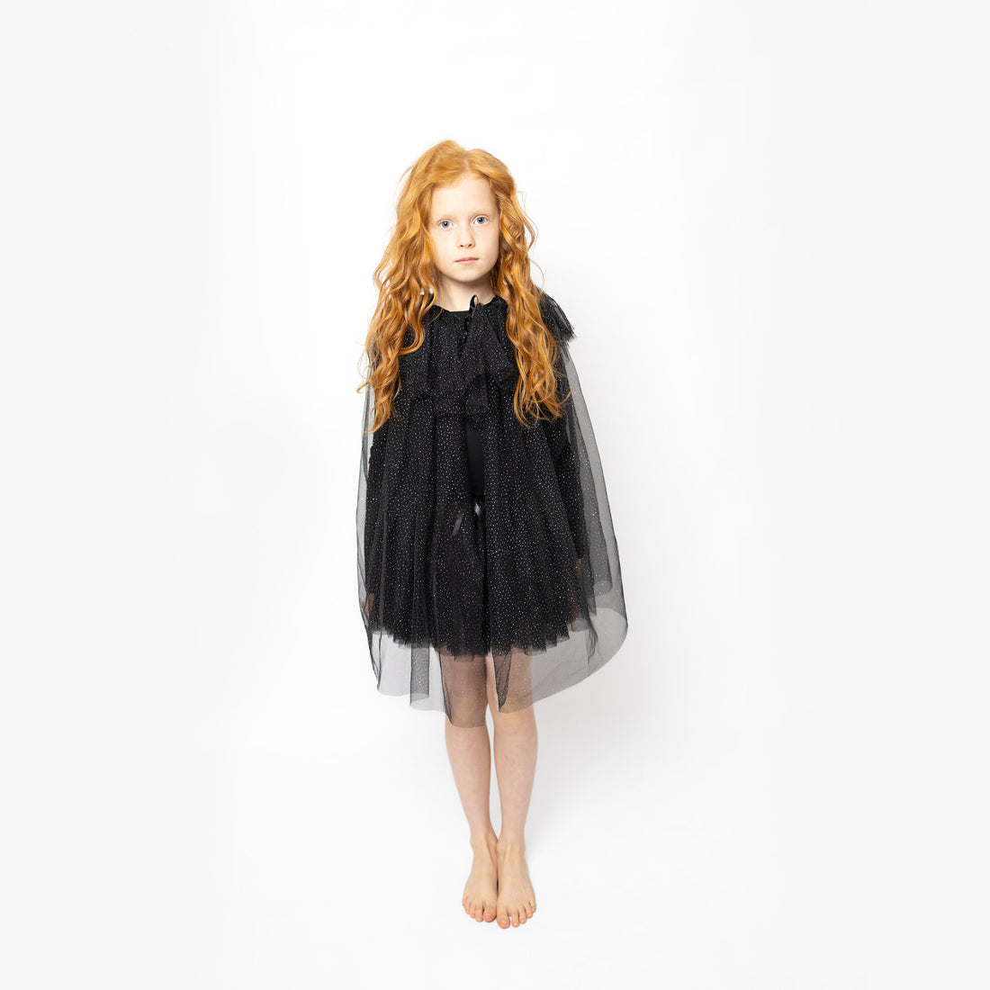 Niña con la capa mágica Trisha negra de tul con brillo de Billy Loves Audrey sobre un vestido negro